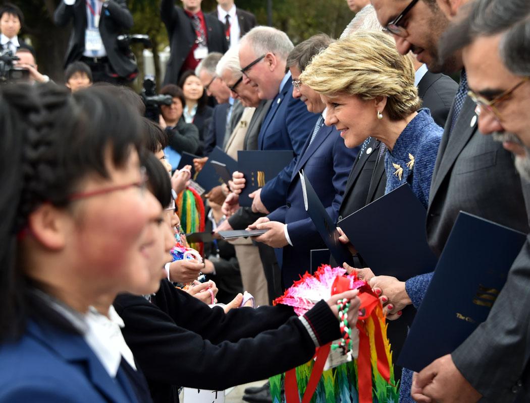 The Hon Julie Bishop MP, Minister for Foreign Affairs receiving paper cranes from schoolchildren at the Hiroshima Cenotaph.