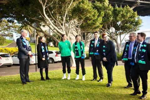 Group photo of several people having a discussion outdoors about the FIFA Women’s World Cup 2023.